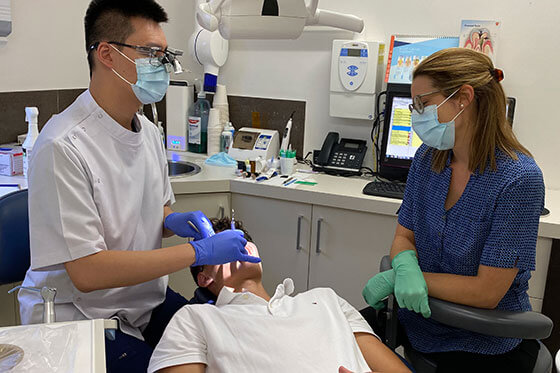 Dr Edmund Wong and dental assistant with patient in dentist chair