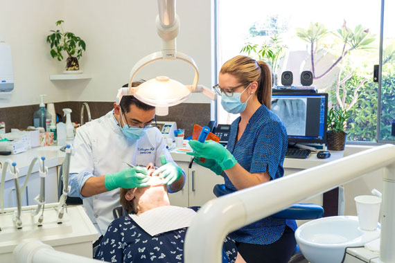 Dr Tran and dental nurse carrying out dental checkup on patient