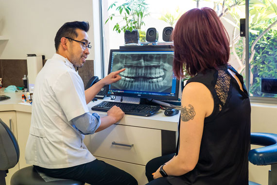 Dentist and patient looking at x-ray of teeth